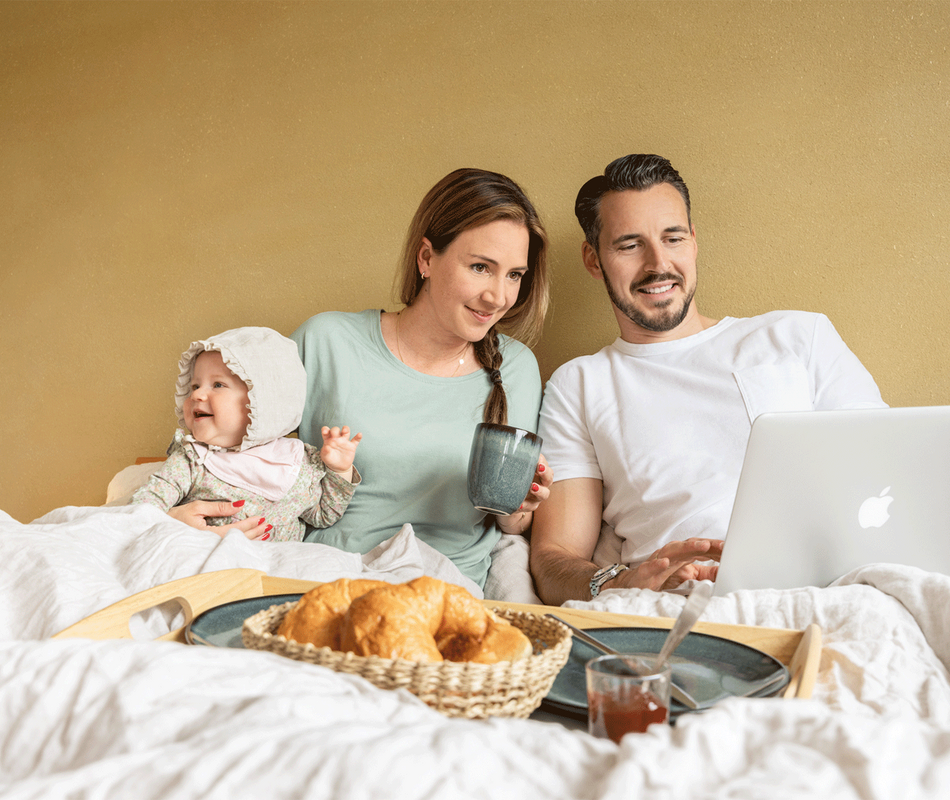 Familie beim Frühstück im Bett